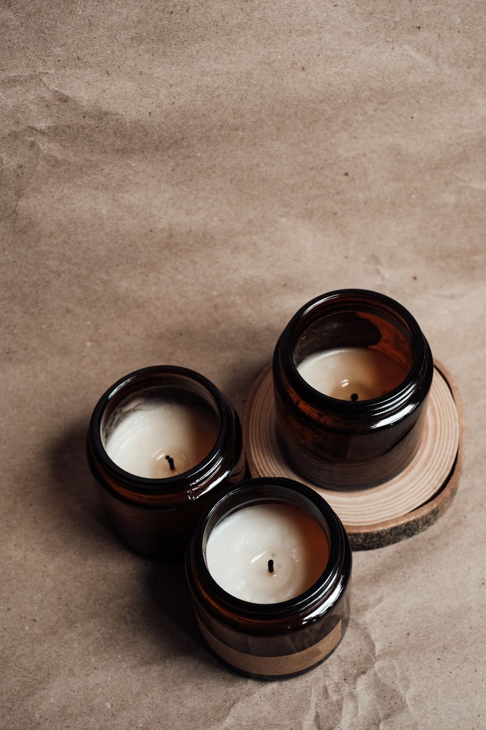 Velas perfumadas em potes âmbar sobre madeira